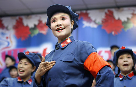 Пожилые женщины в костюмах солдат Красной армии поют революционные песни на концерте в честь юбилея Мао Цзедуна