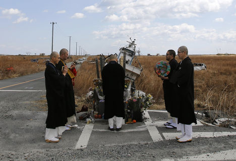 Буддистские монахи молятся за жертв землетрясения и цунами в городе Нами, префектура Фукусима