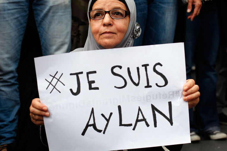 Женщина с плакатом Je suis Aylan на митинге в поддержку беженцев в Париже
