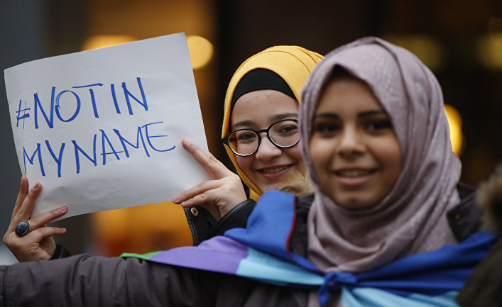Девушки-мусульманки с табличкой «Не от моего имени» во время акции протеста против терроризма в Милане