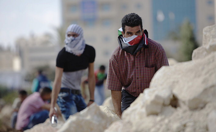 Палестинцы во время столкновений с израильскими полицейскими рядом с городом Рамалла