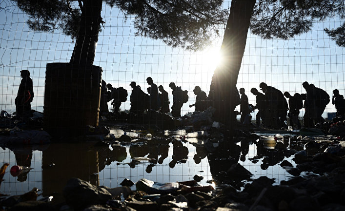 Беженцы идут из деревни Идомени на севере Греции в сторону Македонии 