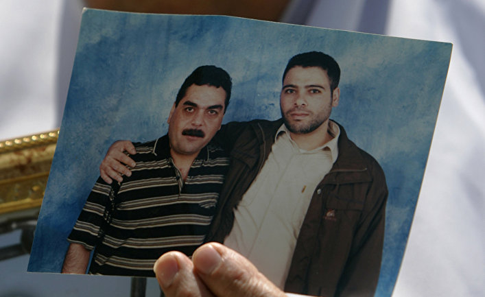 Женщина с портретом своего сына, заключенного израильской тюрьмы, сфотографированного вместе с лидером друзской террористической группировки Самиром Кунтаром