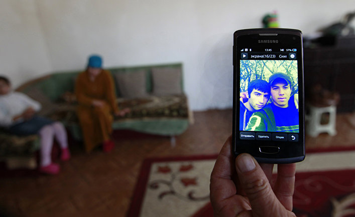Родственники Муслима Куштанашвили из поселка Дуиси в Панкисском ущелье, уехавшего воевать в Сирию в составе «Исламского государства», показывают его фотографию на экране телефона