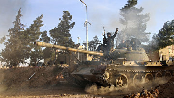 Доброволец, сражающийся на стороне сирийской армии едет на танке в городе Рекка