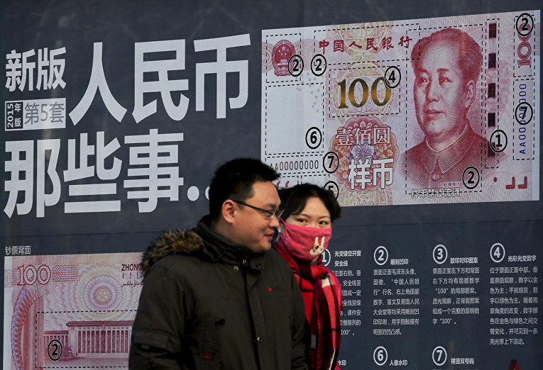 Стенд с информацией о новой купюре в 100 юаней на улице в Пекине
