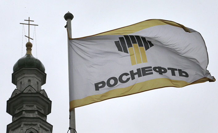 Флаг с логотипом компании «Роснефть» на фоне церкви в Москве