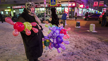 Пожилая женщина продает цветные шары в центре Москвы