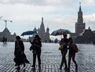 Горожане во время дождя на Красной площади в Москве