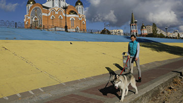 Девушка выгуливает собаку возле Покровского собора в Киеве