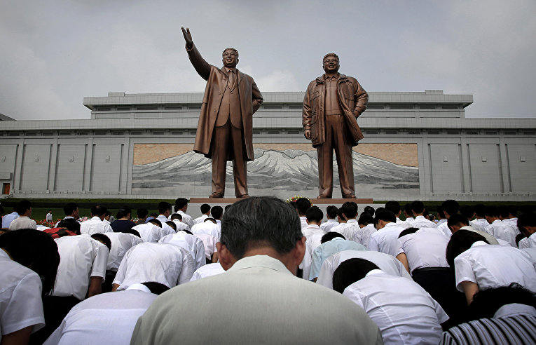 Корейцы у памятников Ким Ир Сена и Ким Чен Иру во время празднования 62-летия окончания Корейской войны