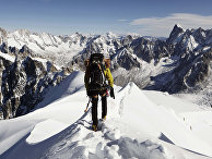 Альпинист на вершине горы Эгюий-дю-Миди во Франции
