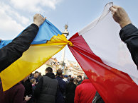 Люди держат связанные флаги Польши и Украины в Варшаве Люди держат связанные флаги Польши и Украины в Варшаве