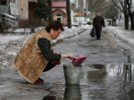 Женщина в Донецке набирает воду из лужи