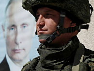 Российский солдат рядом с портретом президента России Владимира Путина в Дамаске