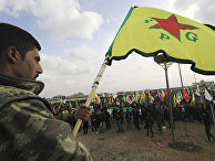 Член сил самообороны сирийских курдов (YPG) во время демонстрации в городе Амуда в Сирии