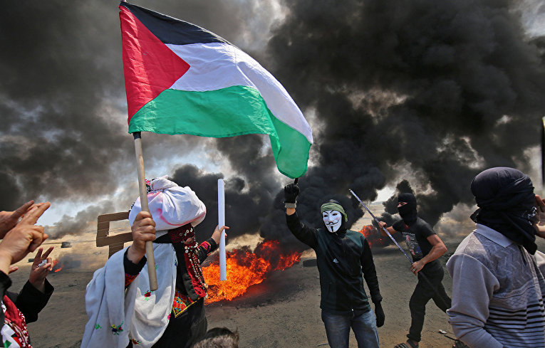 Палестинские демонстранты во время акции протеста против переноса посольства США в Иерусалим на границе Израиля и сектора Газа