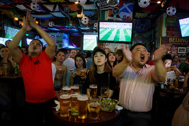 Люди смотрят футбольный матч чемпионата мира по футболу между командами России и Саудовской Аравии в баре в Пекине, Китай