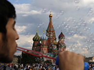 Молодой человек пускает мыльные пузыри на Красной площади в Москве