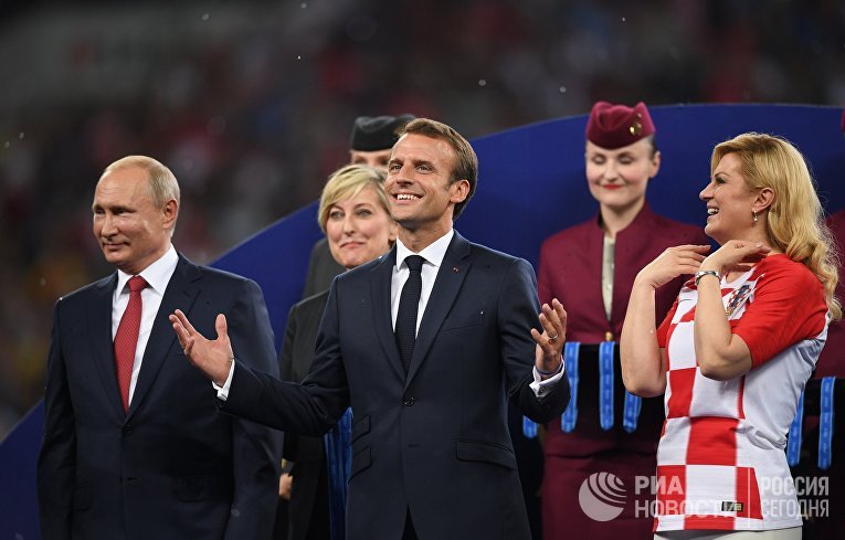 Президент РФ Владимир Путин, президент Франции Эммануэль Макрон и президент Хорватии Колинда Грабар-Китарович (слева направо) на церемонии награждения победителей чемпионата мира по футболу FIFA 2018 года на стадионе "Лужники"