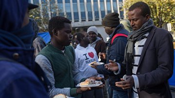 Раздача еды в лагере мигрантов в районе Сталинград в Париже