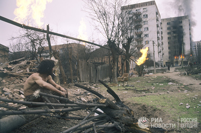 Житель Грозного смотрит на горящие дома