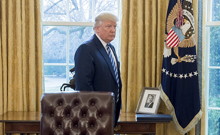 Президент США Дональд Трамп у фотографии своего отца Фреда Трампа в Овальном кабинете в Белого дома в Вашингтоне