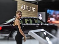 Девушка у автомобиля Aurus Senat на Московском международном автомобильном салоне 2018