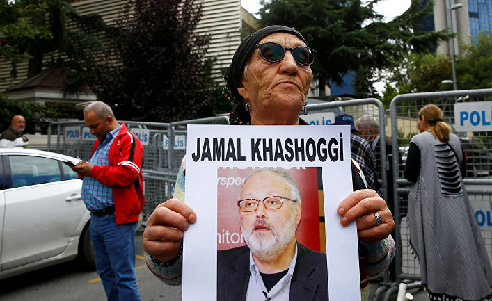 Борец за права человека держит портрет журналиста Джамаля Хашогги во время протестов у консульства Саудовской Аравии в Стамбуле, Турция