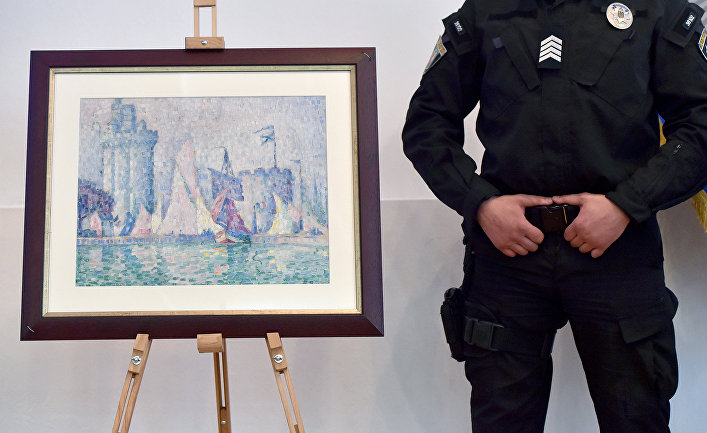 Украинский полицейский охраняет картину «Вход в порт Ла-Рошель» французского художника Поля Синьяка в Министерстве внутренних дел Украины в Киеве