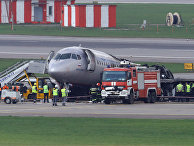 Сотрудники экстренных служб на месте аварии пассажирского самолета Sukhoi Superjet-100 в аэропорту Шереметьево