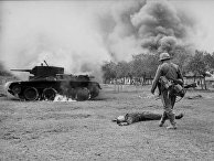 Немецкий пехотинец возле горящего советского танка БТ-5