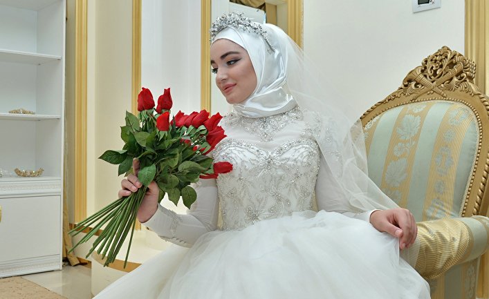 Модель демонстрирует свадебное платье в салоне магазина в Грозном