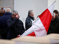 Мужчина держит польский флаг в Вильнюсе, Литва