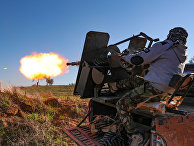 Сирийский боевик обстрелдивает позиции правительственных войск в провинции Идлиб