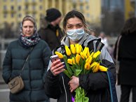 Девушка с цветами и в маске на Пушкинской набережной в Парке Горького в Международный женский день в Москве Девушка с цветами и в маске на Пушкинской набережной в Парке Горького в Международный женский день в Москве