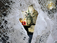 Граффити, изображающее лицо Статуи свободы, через разбитую витрину магазина в Нью-Йорке, США