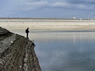 Мужчина ловит рыбу на берегу Аянского водохранилища в Крыму Мужчина ловит рыбу на берегу Аянского водохранилища в Крыму