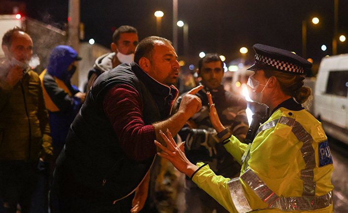 Мужчина спорит с полицейским , ожидая посадки на паром в Дувре