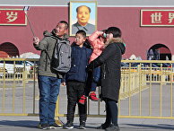 Семья фотографируется у портрета Мао Цзэдуна на центральной площади Пекина - Тяньаньмэнь