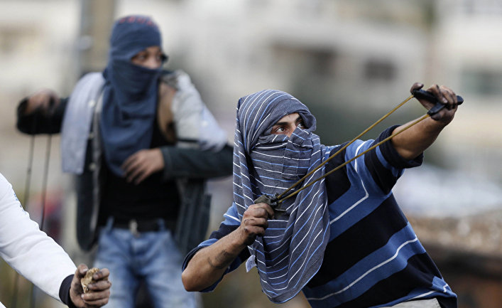 Палестинцы кидают камни во время столкновений с израильскими солдатами