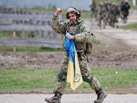 Украинский военнослужащий с национальным флагом Украинский военнослужащий с национальным флагом