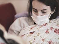 Девушка дома в медицинской маске Девушка дома в медицинской маске
