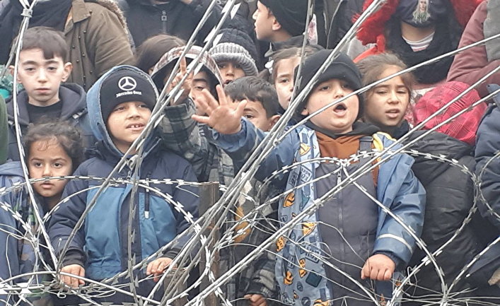 Беженцы возле заграждения из колючей проволоки