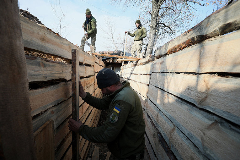 Украинские военнослужащие роют окопы недалеко от города Золотое