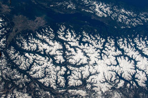 Заснеженные Прибрежные горы Британской Колумбии и город Ванкувер слева вверху.  