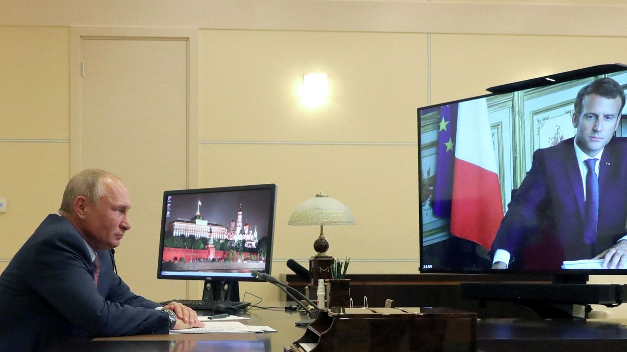 Президент России Владимир Путин беседует со своим французским коллегой Эммануэлем Макроном