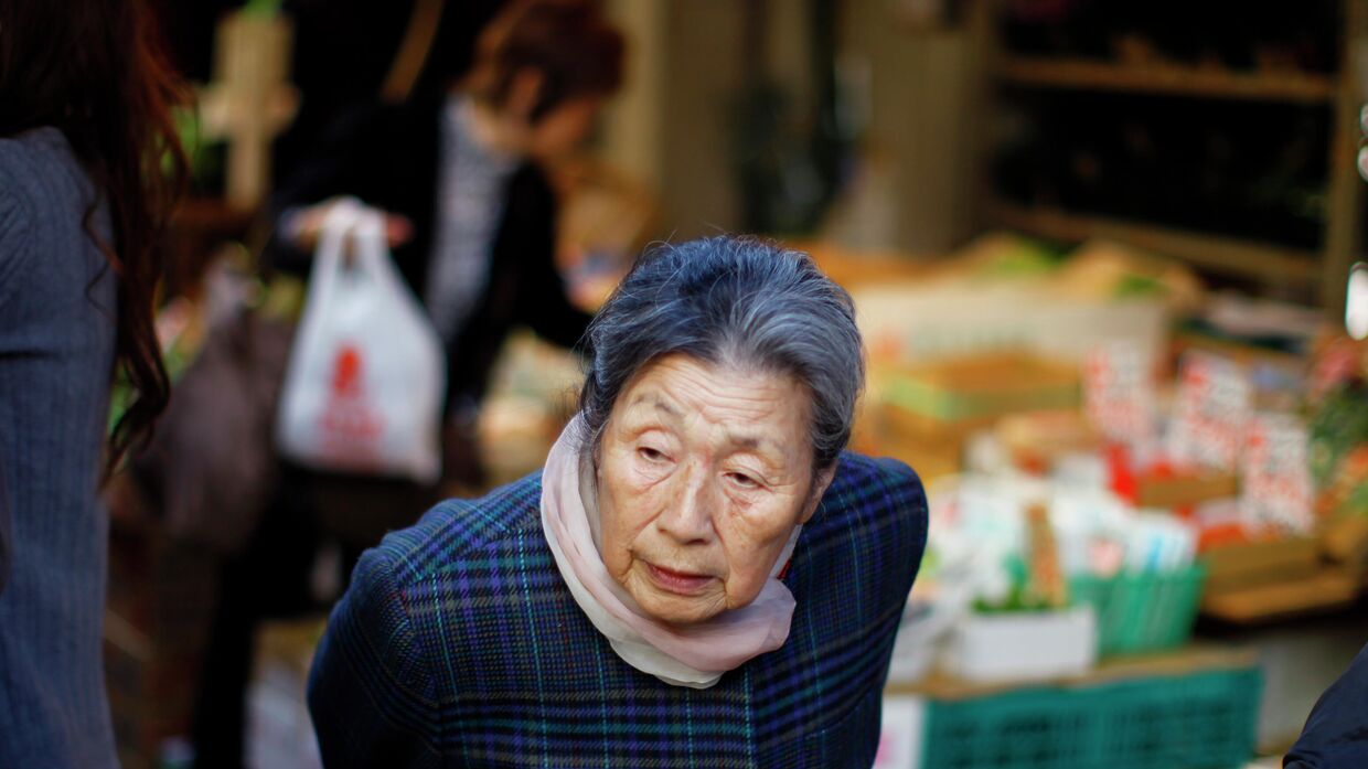 Пожилая женщина на рынке в Токио, Япония