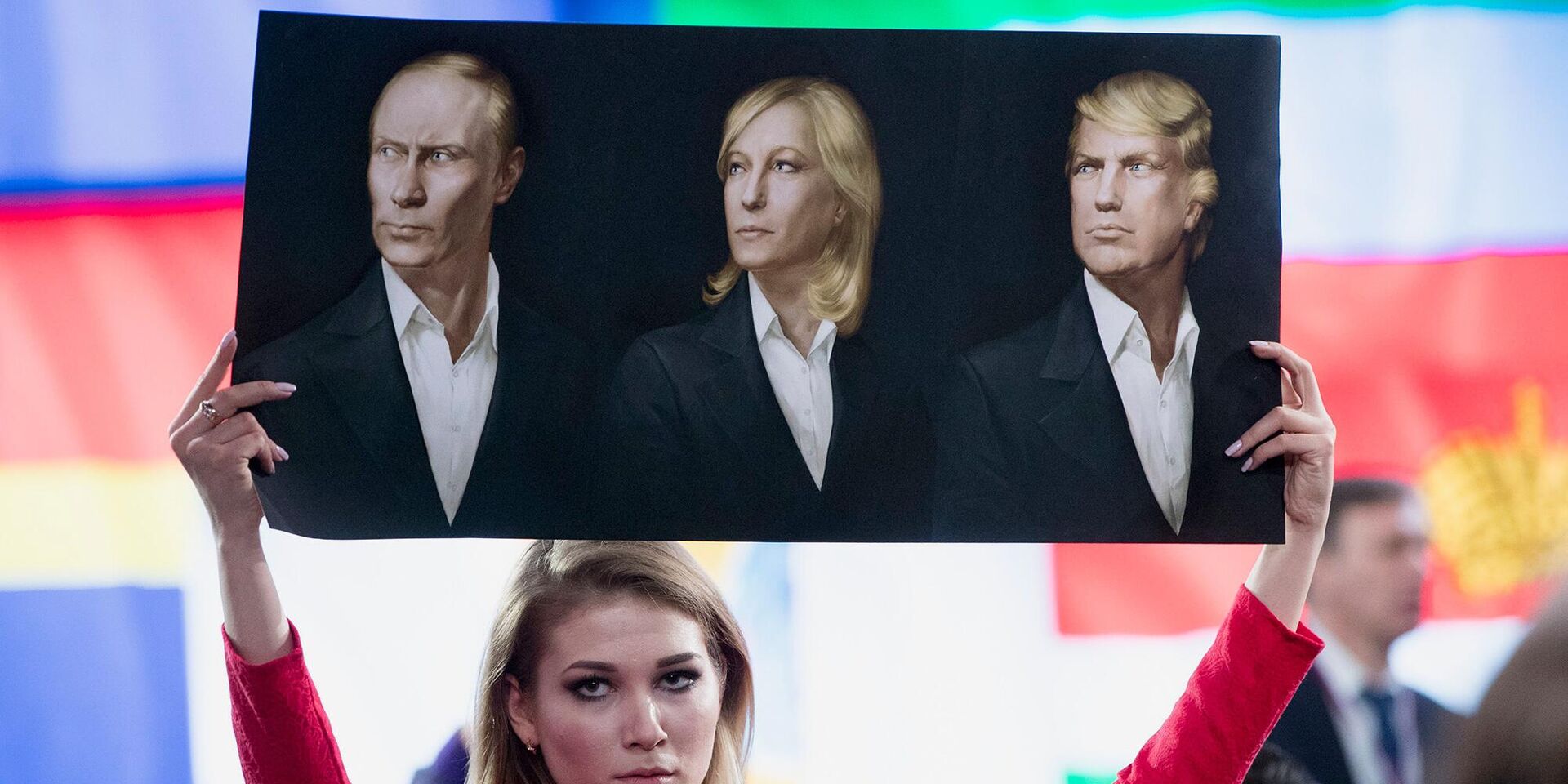 Журналист держит плакат с портретами Владимира Путина, Марин Ле Пен и Дональда Трампа - ИноСМИ, 1920, 27.04.2022