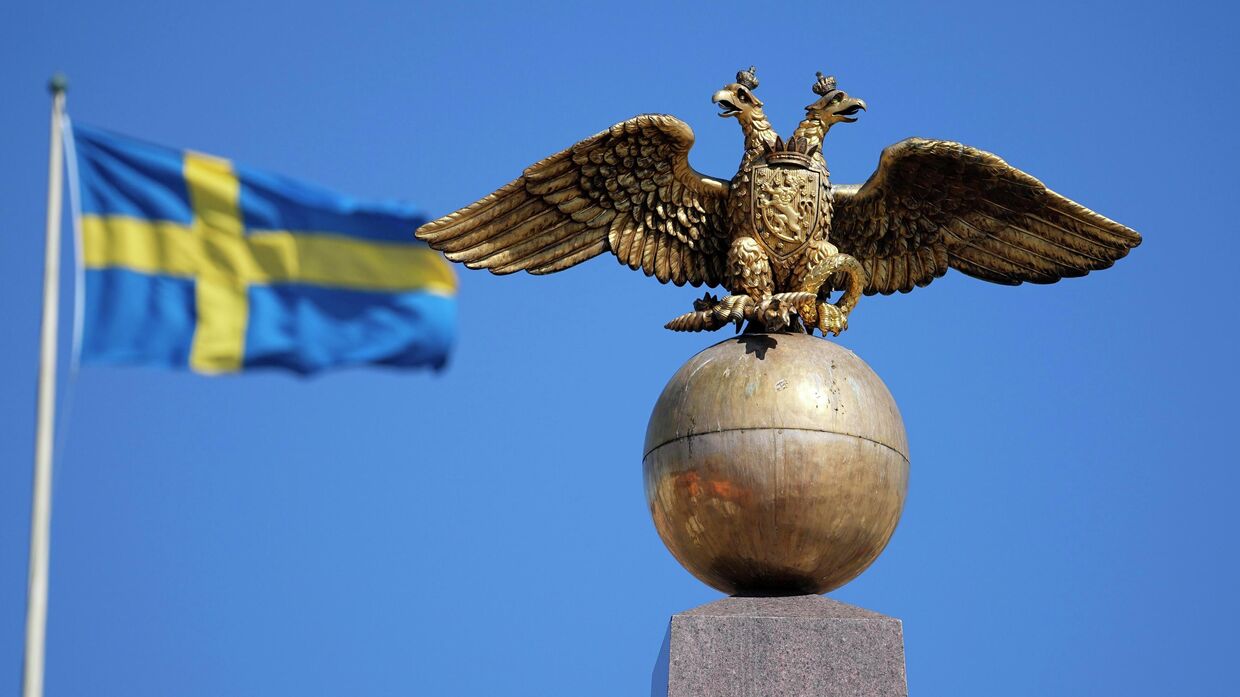 Двуглавый орел на фоне флага Швеции в Хельсинки, Финляндия